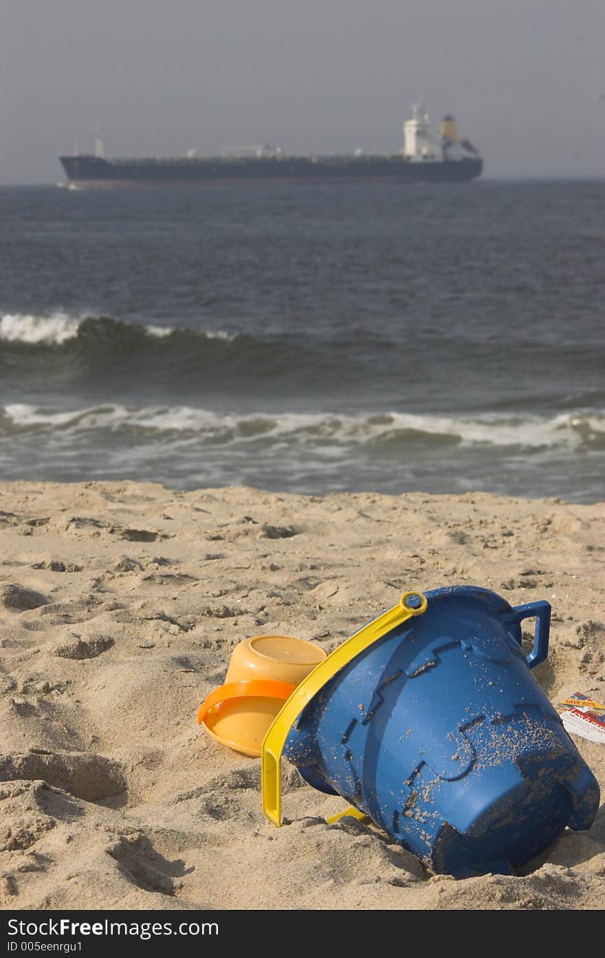 Toys on the beach with ship on horizon