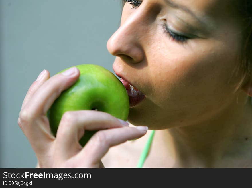 Girl taking a bite out of a green apple. Girl taking a bite out of a green apple