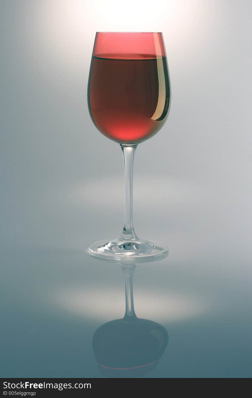 Single red wine glass and reflection