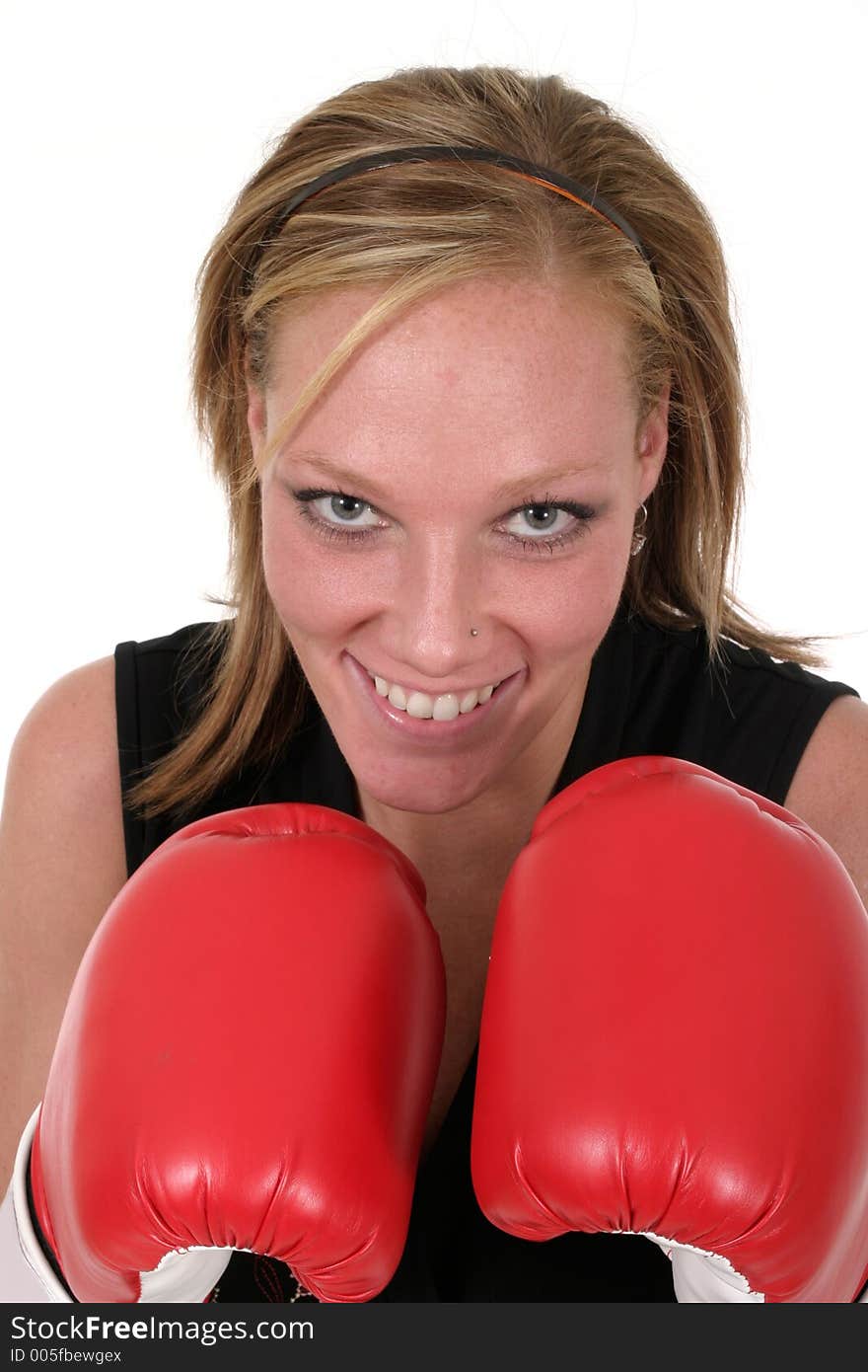 Attractive blonde executive business woman puts on the boxing gloves to do battle in the corporate world. Attractive blonde executive business woman puts on the boxing gloves to do battle in the corporate world.