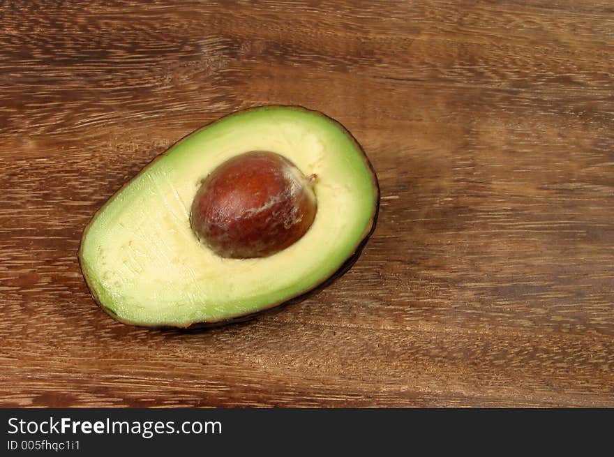 Avocado half over a wooden background