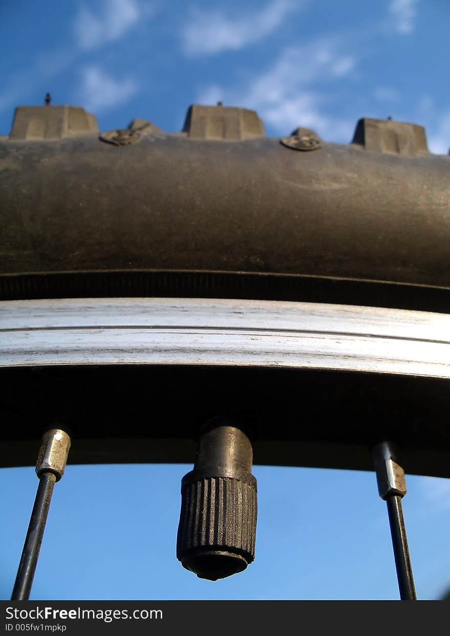 Bicycle air intake against some blue sky and clouds.  Shallow depth of field.  Focus on the intake, the tire it self begins to go out of focus near the top. Bicycle air intake against some blue sky and clouds.  Shallow depth of field.  Focus on the intake, the tire it self begins to go out of focus near the top.