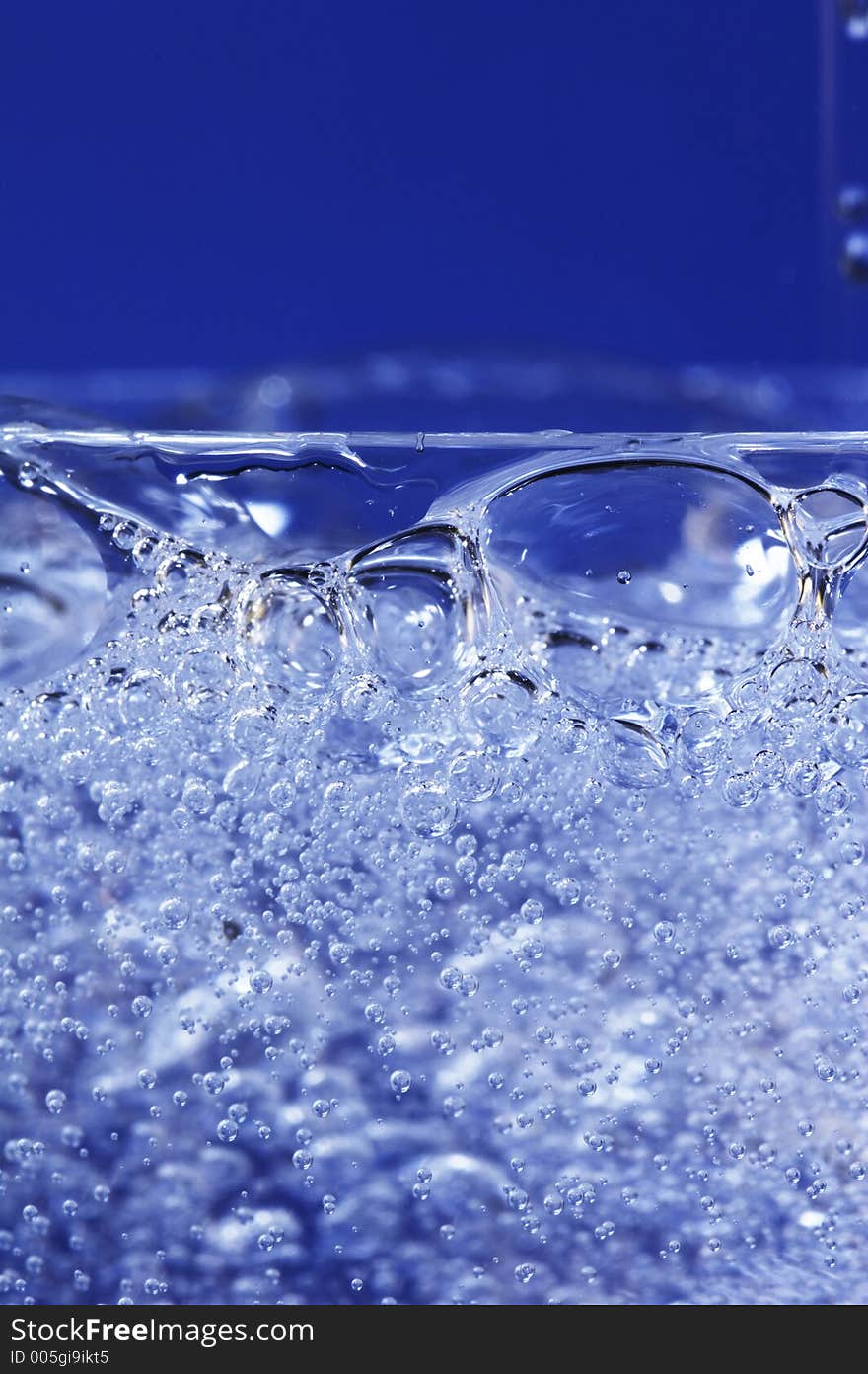 Sparkling water dropping in a glass with many bubbles. Sparkling water dropping in a glass with many bubbles