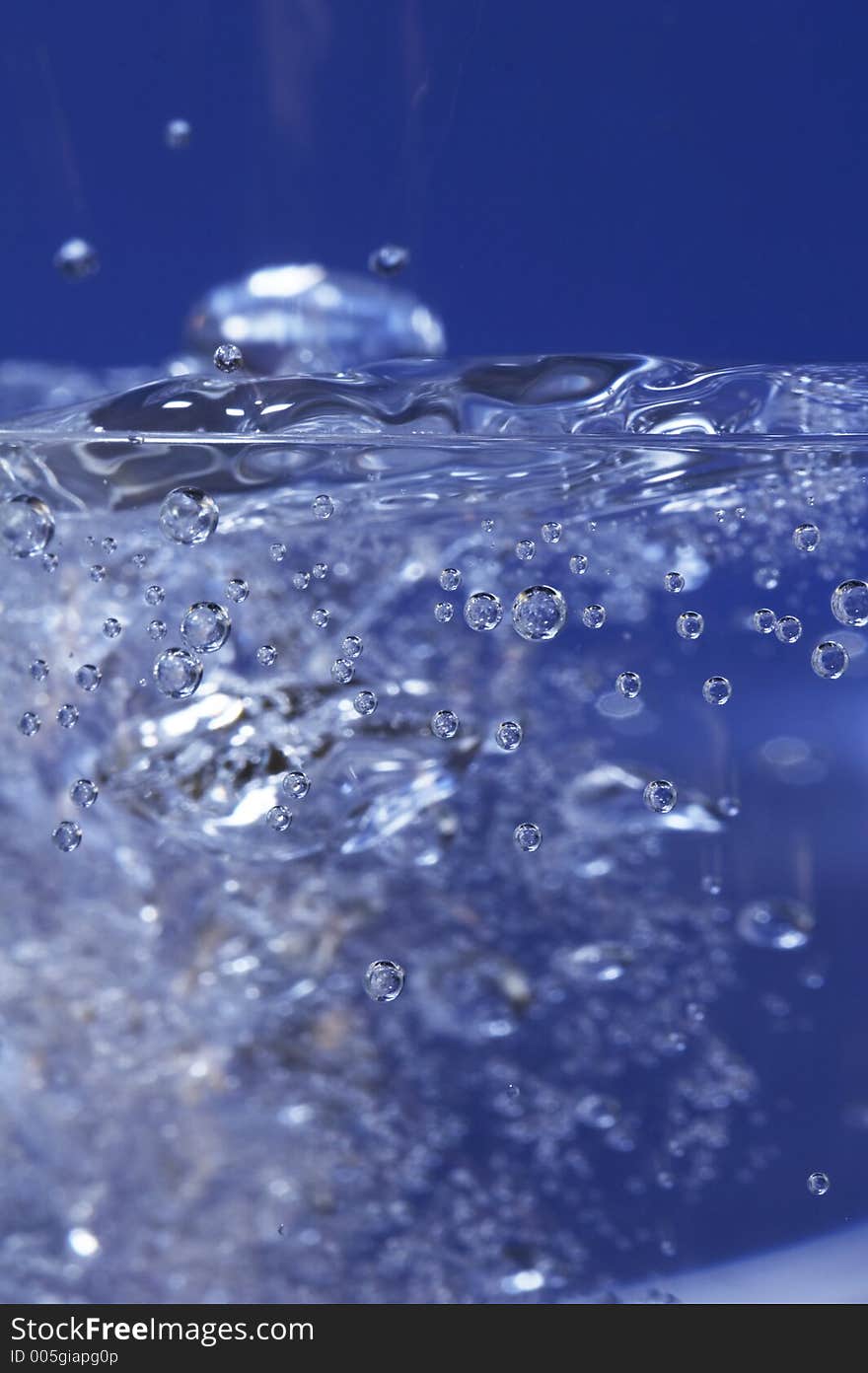 Sparkling water dropping in a glass with many bubbles. Sparkling water dropping in a glass with many bubbles