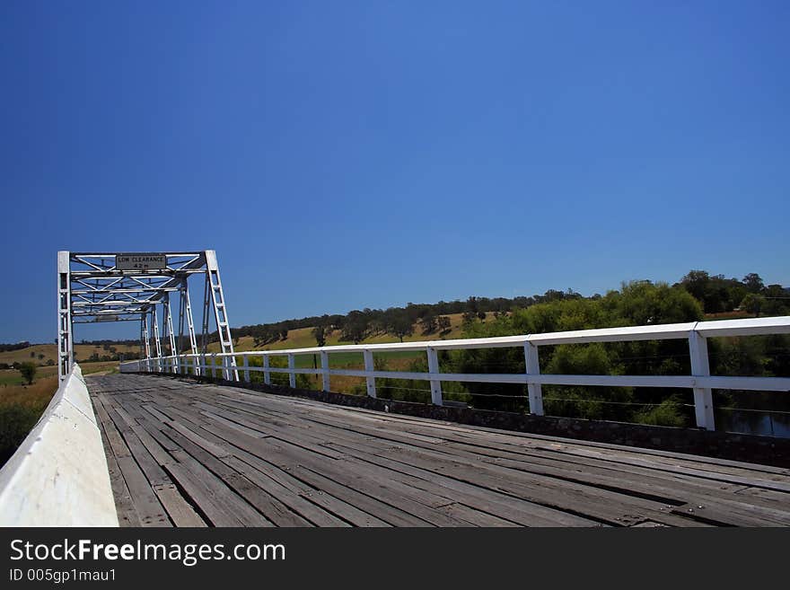 Low clearance steel and wood bridge with big blue sky. Low clearance steel and wood bridge with big blue sky.