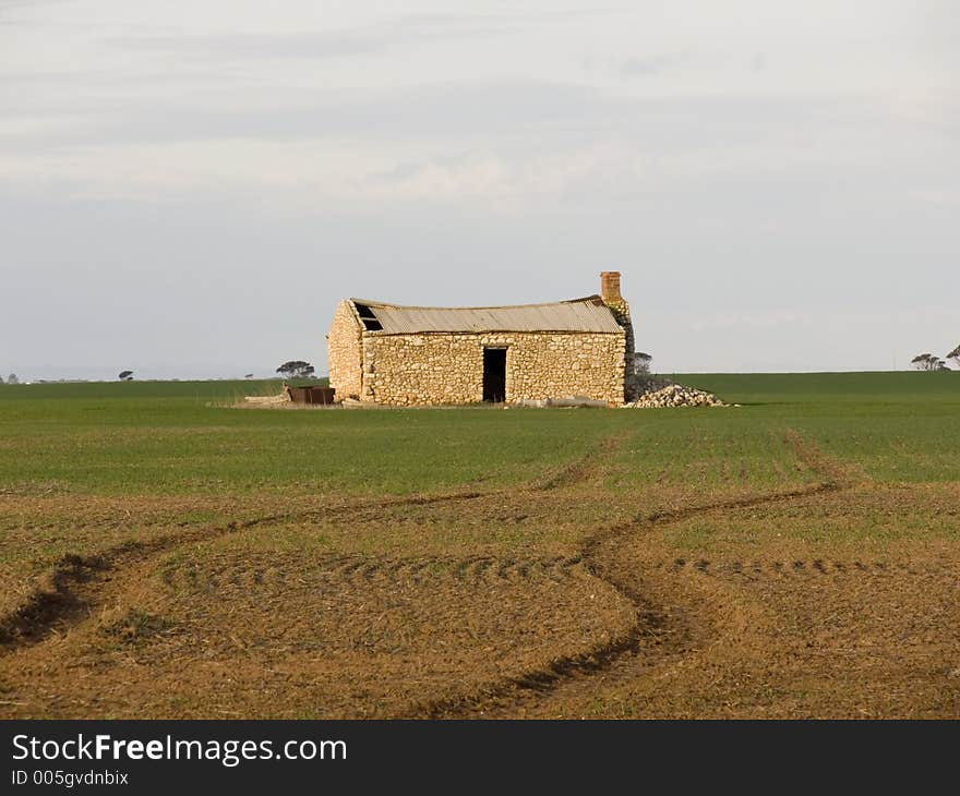 An old farmhouse in the middle of a farmers crop. An old farmhouse in the middle of a farmers crop