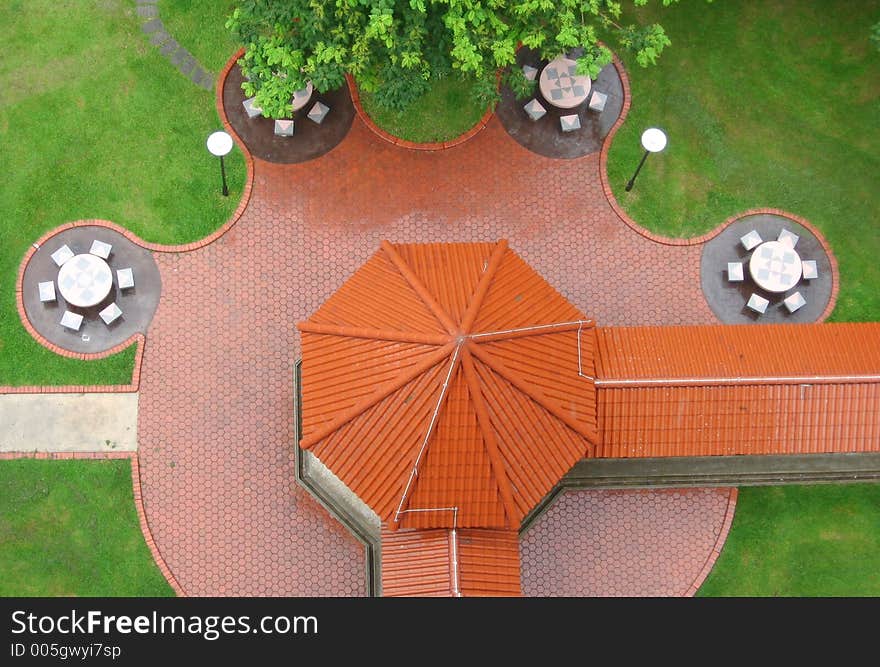 Top view of a pavillion with tables and chairs forming a pattern around it. Top view of a pavillion with tables and chairs forming a pattern around it