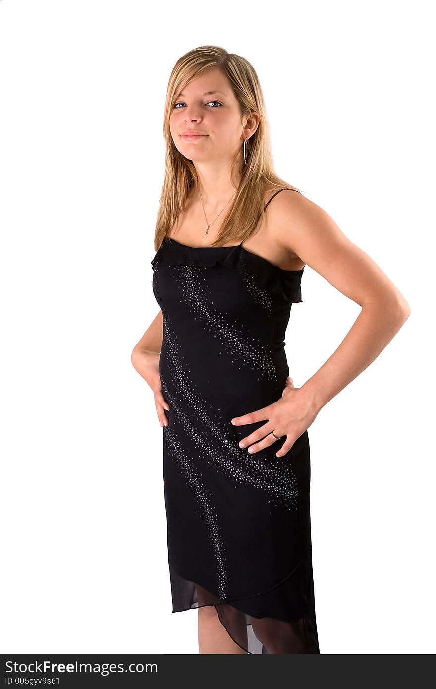 Portrait of a beautiful young blonde woman in a black dress isolated on a white background. Hands on hips. Portrait of a beautiful young blonde woman in a black dress isolated on a white background. Hands on hips.