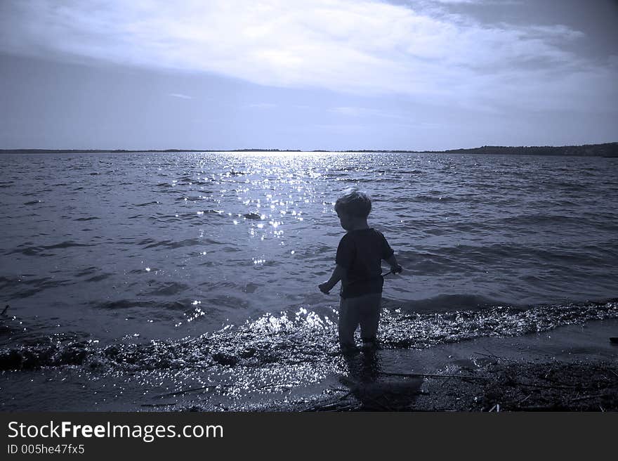 Small child entering a lake. Small child entering a lake.