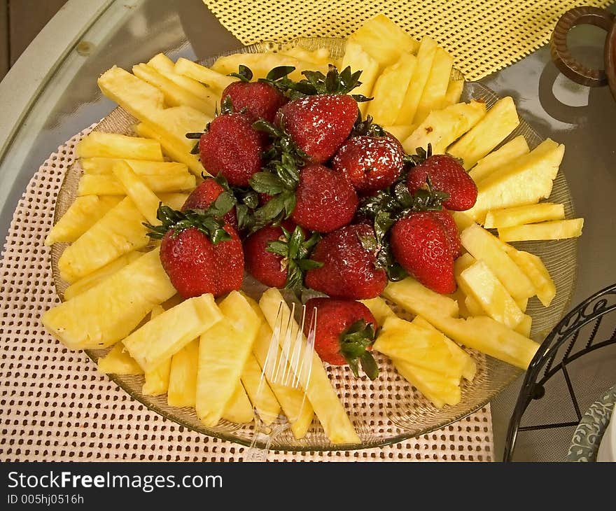 A platter of fresh strawberries and cut pineapple. A platter of fresh strawberries and cut pineapple.