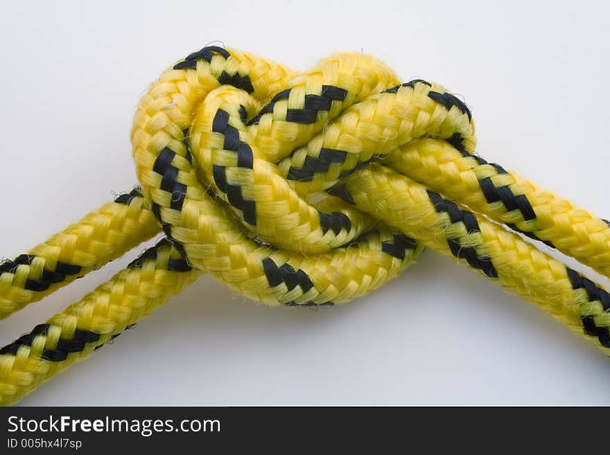 Knot on a yellow-and-black rope on white background with embedded clipping path. Knot on a yellow-and-black rope on white background with embedded clipping path