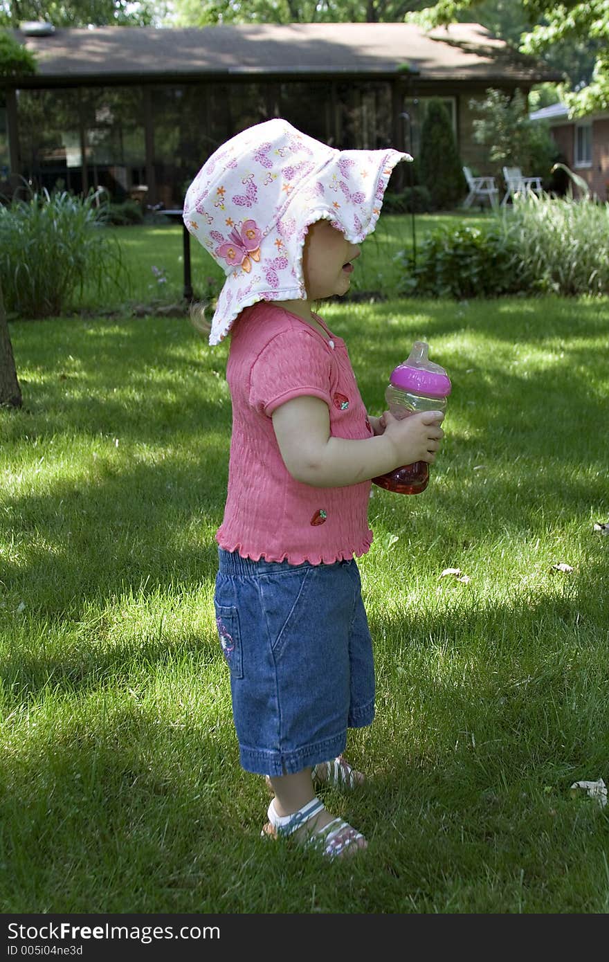 Toddler Girl In Sun Hat With Juice Cup