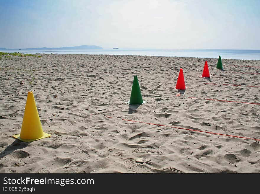 Multicolored cones on the beach, arranged for sports activities