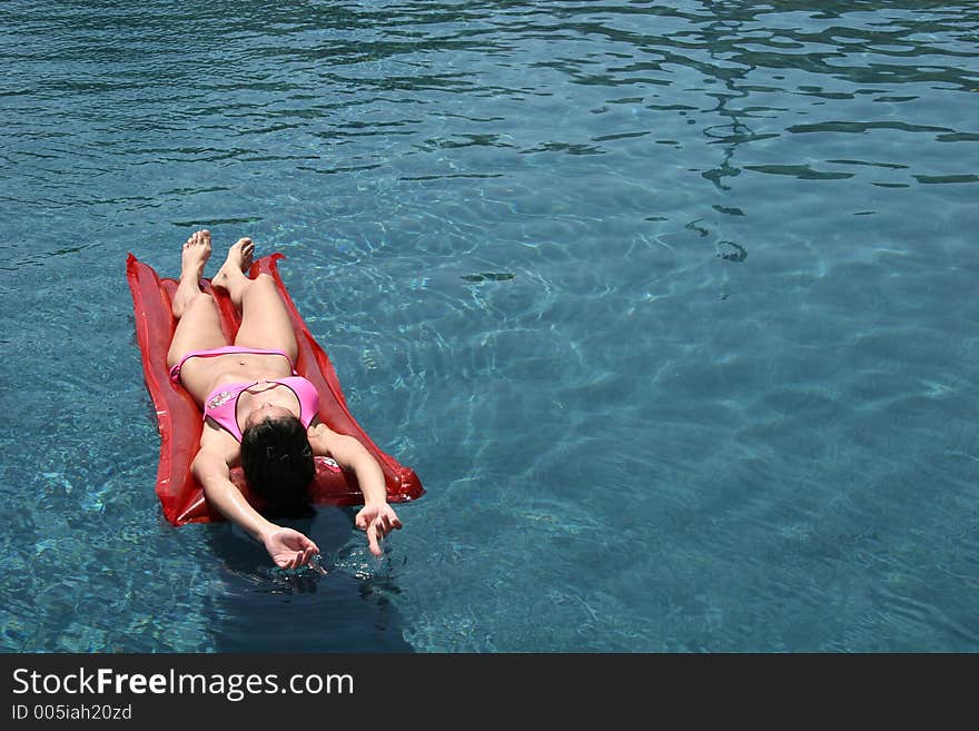 Girl Floating In Swimming Pool