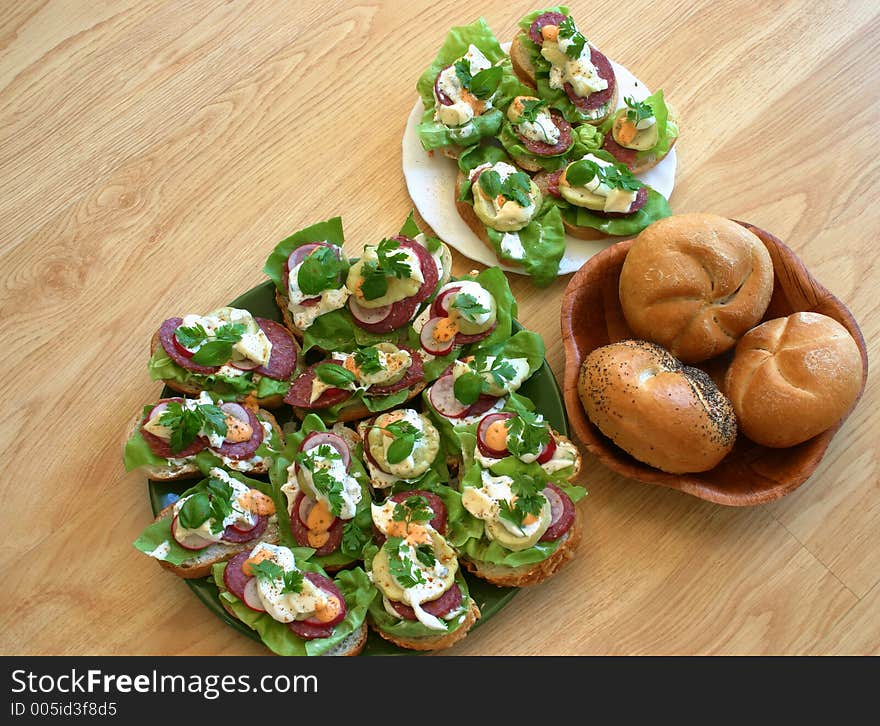 Just made sandwiches put together with fresh breadroll on the table in kitchen. Just made sandwiches put together with fresh breadroll on the table in kitchen