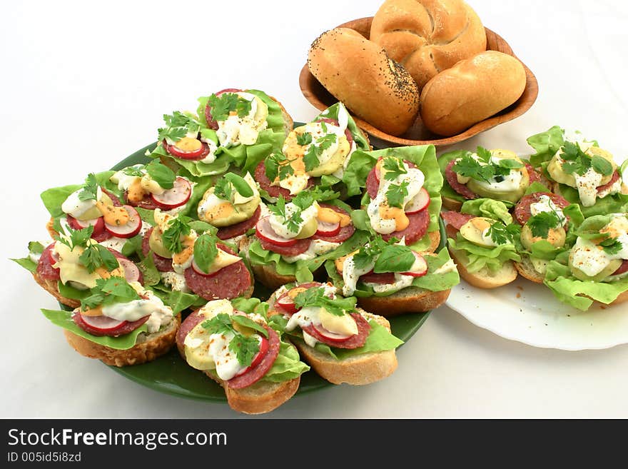 Fresh springtime sandwiches put together on plates next to breadrolls. Fresh springtime sandwiches put together on plates next to breadrolls