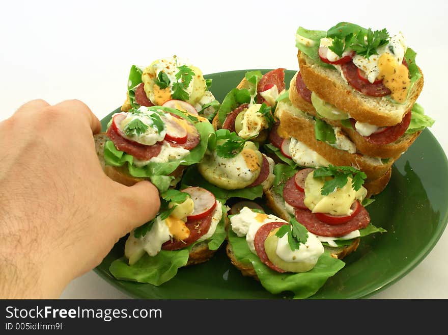 Hand picking a tasty sandwich from a plate. Hand picking a tasty sandwich from a plate