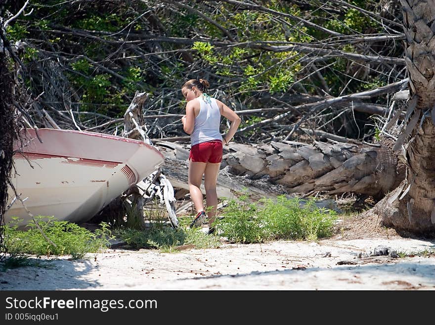 Young girl checks out boat destroyed by hurricane and abandoned. Young girl checks out boat destroyed by hurricane and abandoned