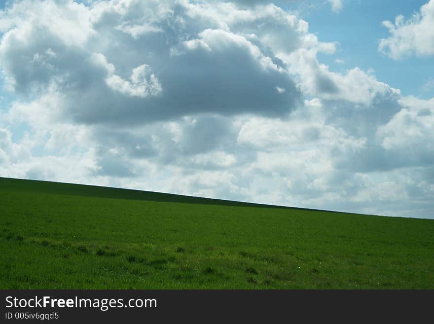 Clouds in blue sky over green hills. Clouds in blue sky over green hills