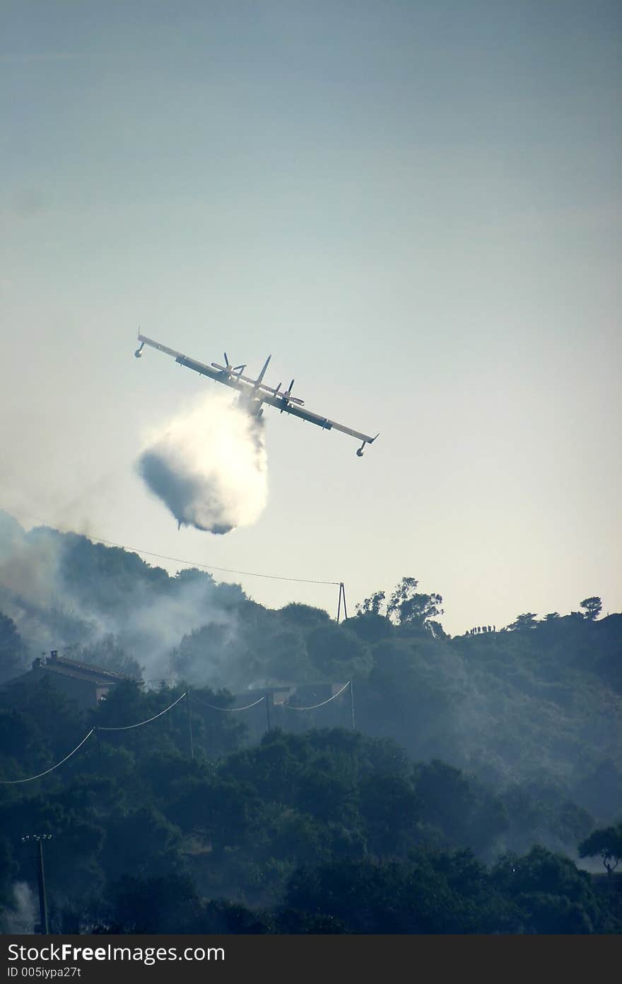 Fire in the corsican mountains: a plane is throwing water on the fire