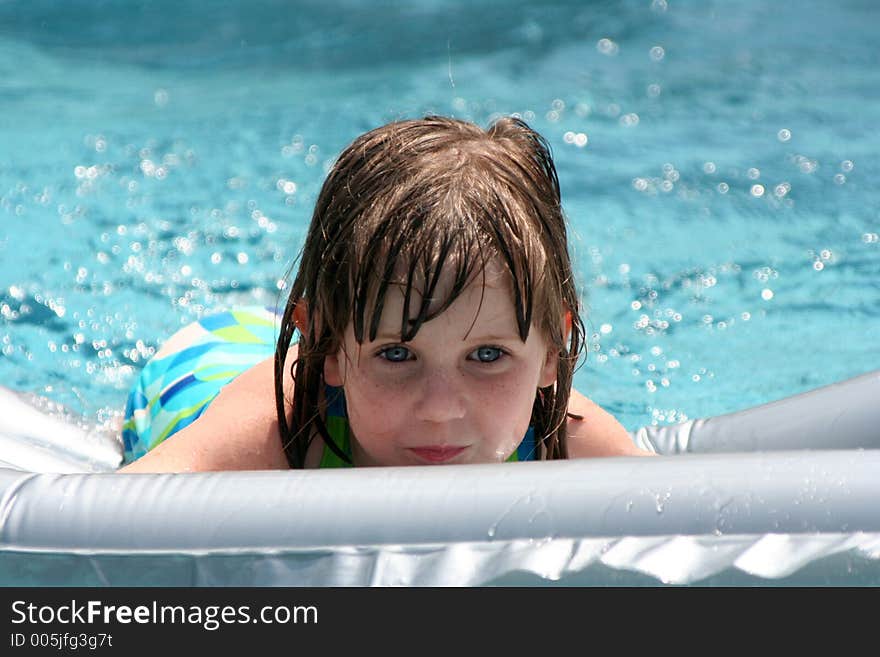 Girl in swimming pool on raft