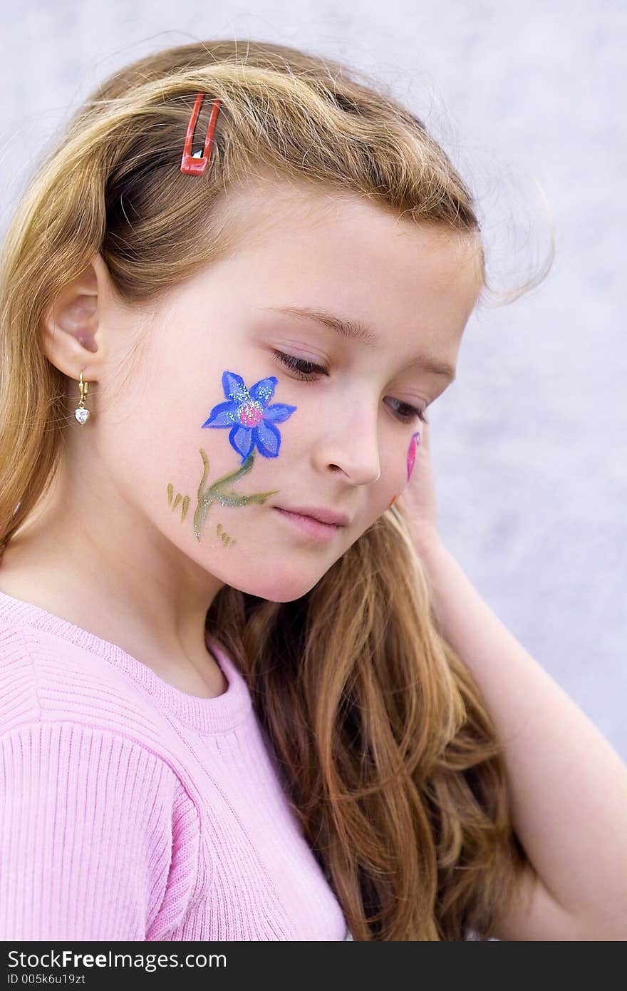 Beautiful young girl with a flower and butterfl drawing on her cheek. Beautiful young girl with a flower and butterfl drawing on her cheek