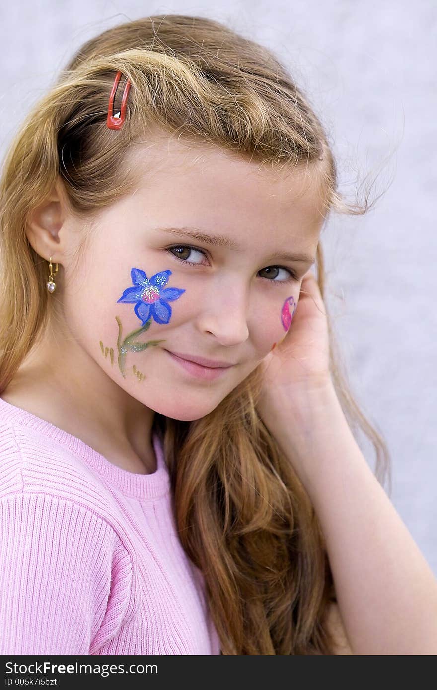 Beautiful young girl with a flower and butterfl drawing on her cheek. Beautiful young girl with a flower and butterfl drawing on her cheek