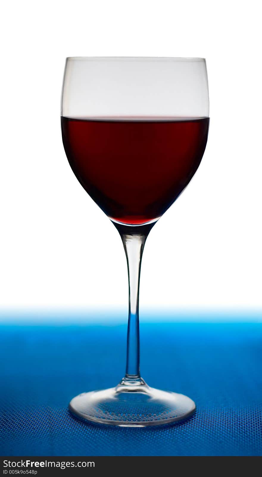 A glass of red wine on blue