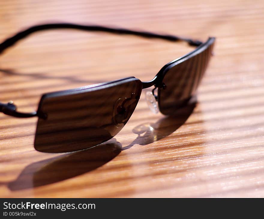 Mens' sunglasses in strong light and shadow in very shallow focus. Mens' sunglasses in strong light and shadow in very shallow focus.