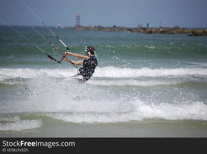 A kitesurfer churns up the surf as he turns the corner at Ponce Inlet Beach, Florida. A kitesurfer churns up the surf as he turns the corner at Ponce Inlet Beach, Florida