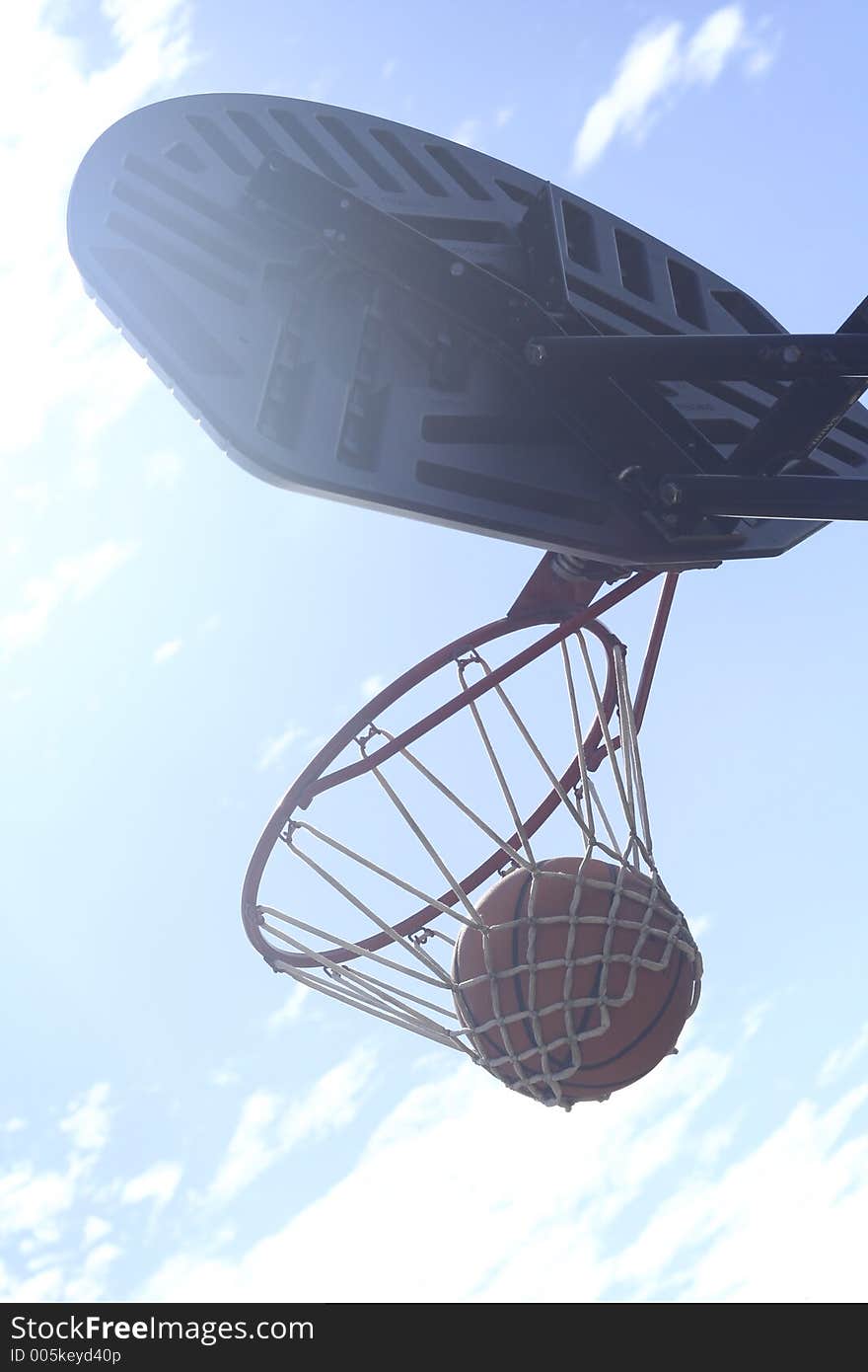 Basketball is hung waiting to be dropped through the hoop. Basketball is hung waiting to be dropped through the hoop