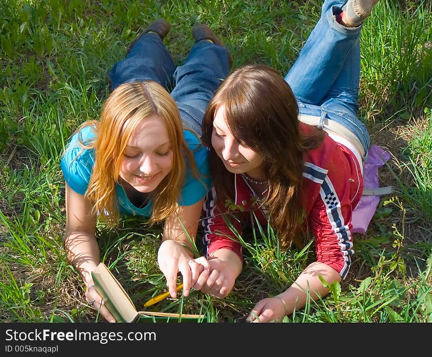 Girlfriends read book lying down. Girlfriends read book lying down