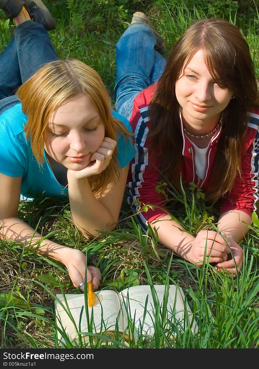 Girlfriends read book lying down. Girlfriends read book lying down