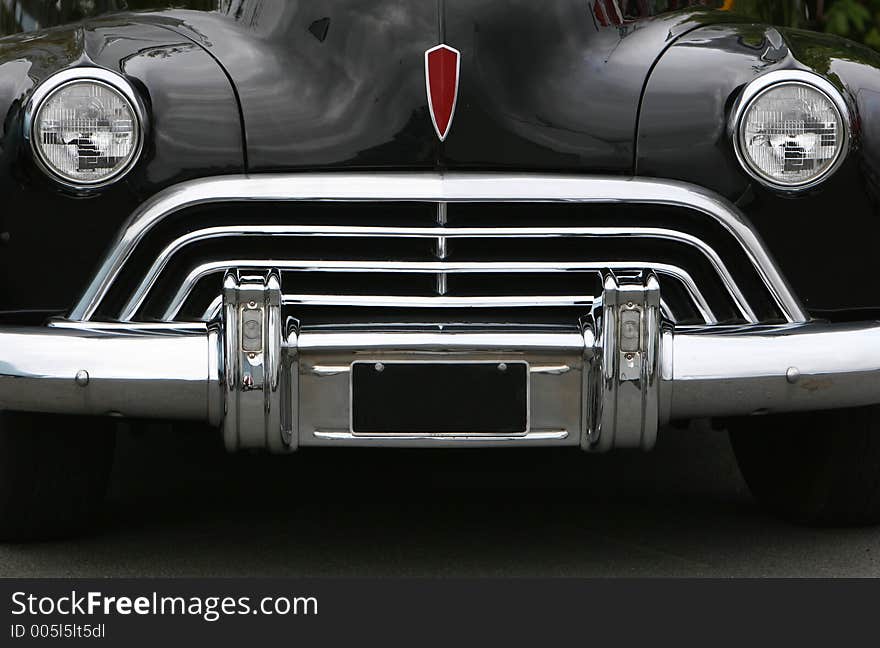 Photograph of an old classic car in mint condition, shining chrome and highly polished finish , almost like a face with mouth eyes and nose. Photograph of an old classic car in mint condition, shining chrome and highly polished finish , almost like a face with mouth eyes and nose