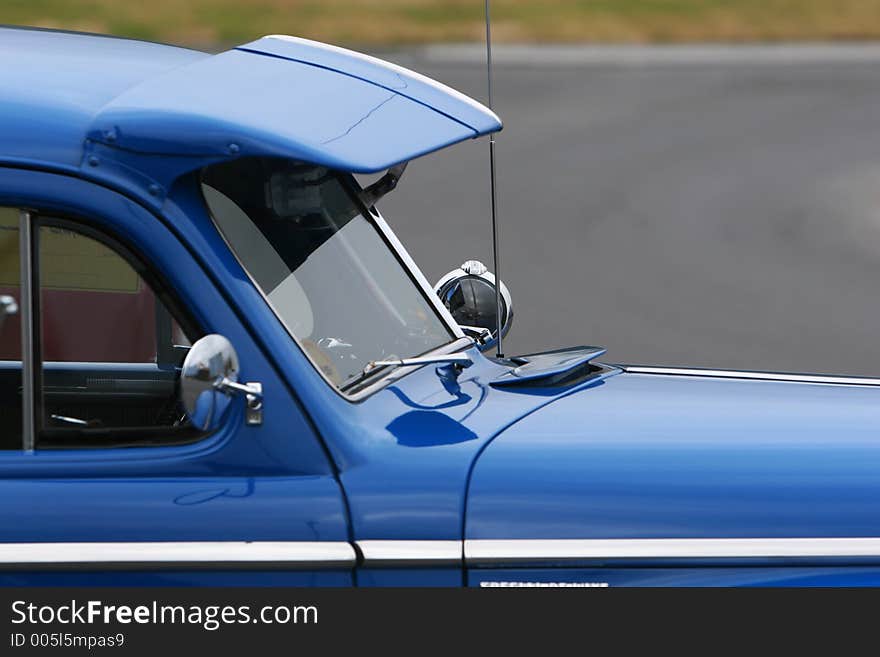 Photograph of an old classic car in mint condition, shining chrome and highly polished finish , front side, cropped shot. Photograph of an old classic car in mint condition, shining chrome and highly polished finish , front side, cropped shot