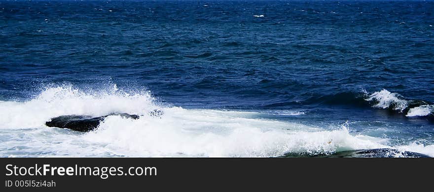 Panorama of the sea with wave on a rock