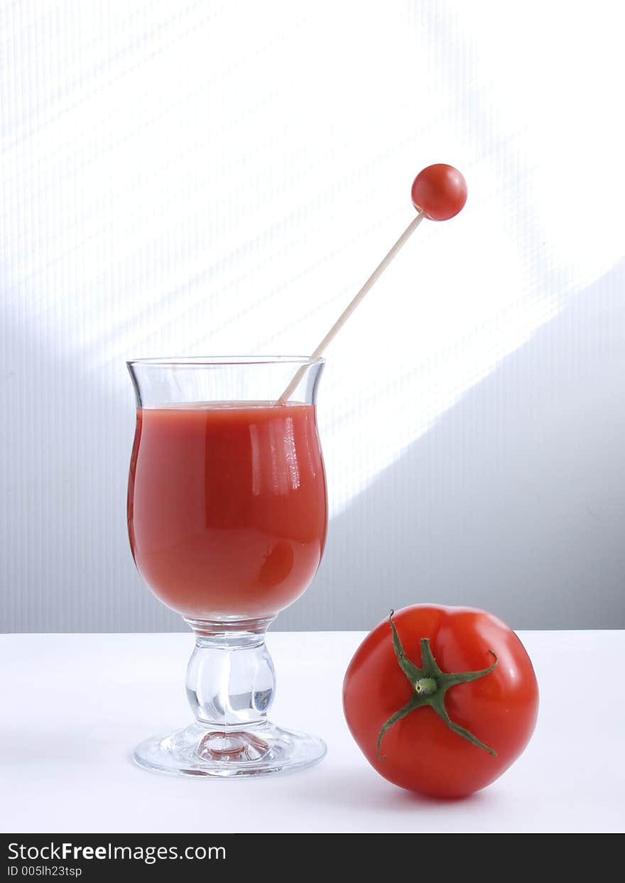 A glass of tomato juice and fresh tomato. A glass of tomato juice and fresh tomato