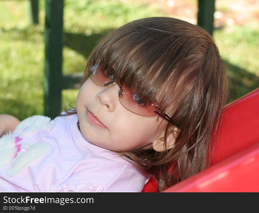 Small child playing outside while wearing sunglasses. Small child playing outside while wearing sunglasses