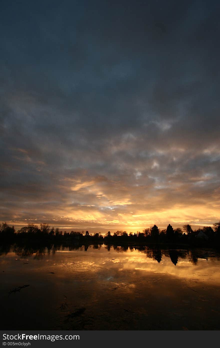 Sunset over a lake in the summer in the countryside  in denmark
 a lake in denmark at sunset. Sunset over a lake in the summer in the countryside  in denmark
 a lake in denmark at sunset