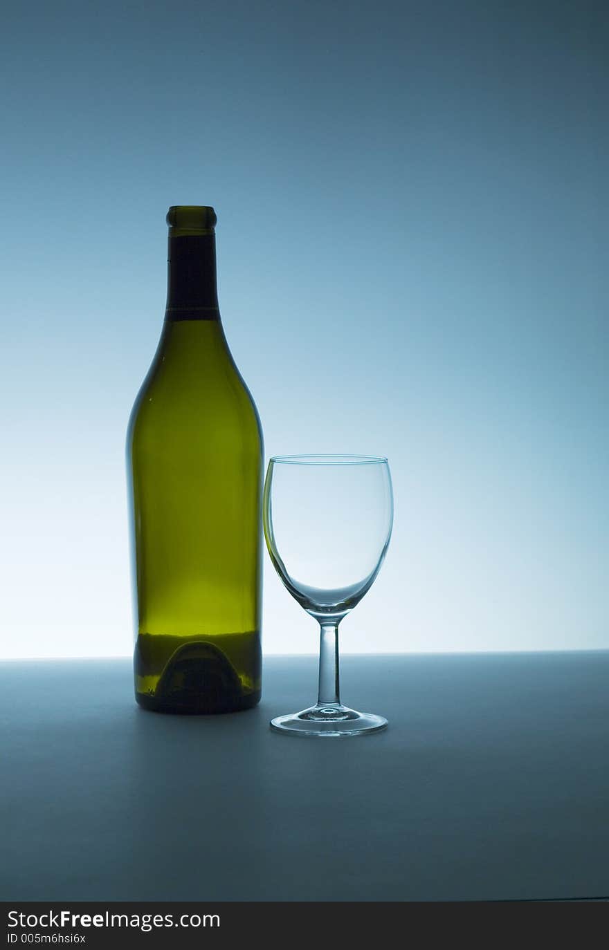 Wine bottle and glass, both are empty. Backlight with small amount of fill. Wine bottle and glass, both are empty. Backlight with small amount of fill.