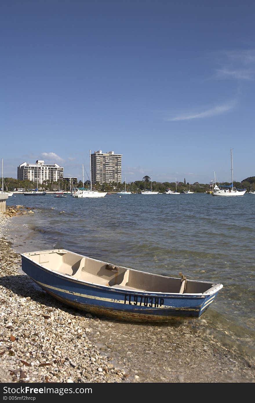 Small wooden boat on the shoreline of island park with the skyline of sarasota in the background florida united states taken in march 2006