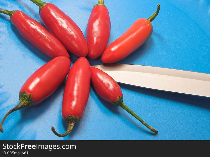 Red Chillies with steak knife and blue