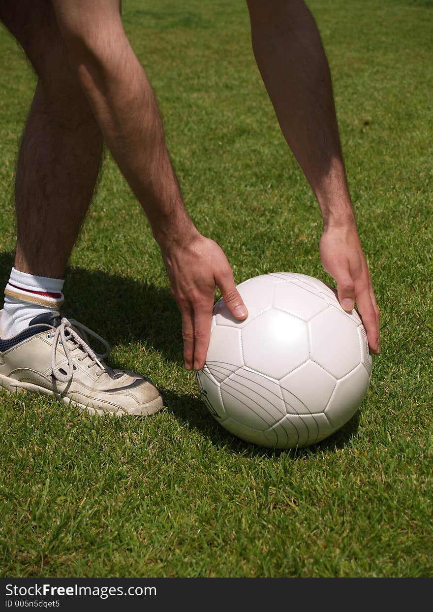 Placing the ball on the grass. Placing the ball on the grass