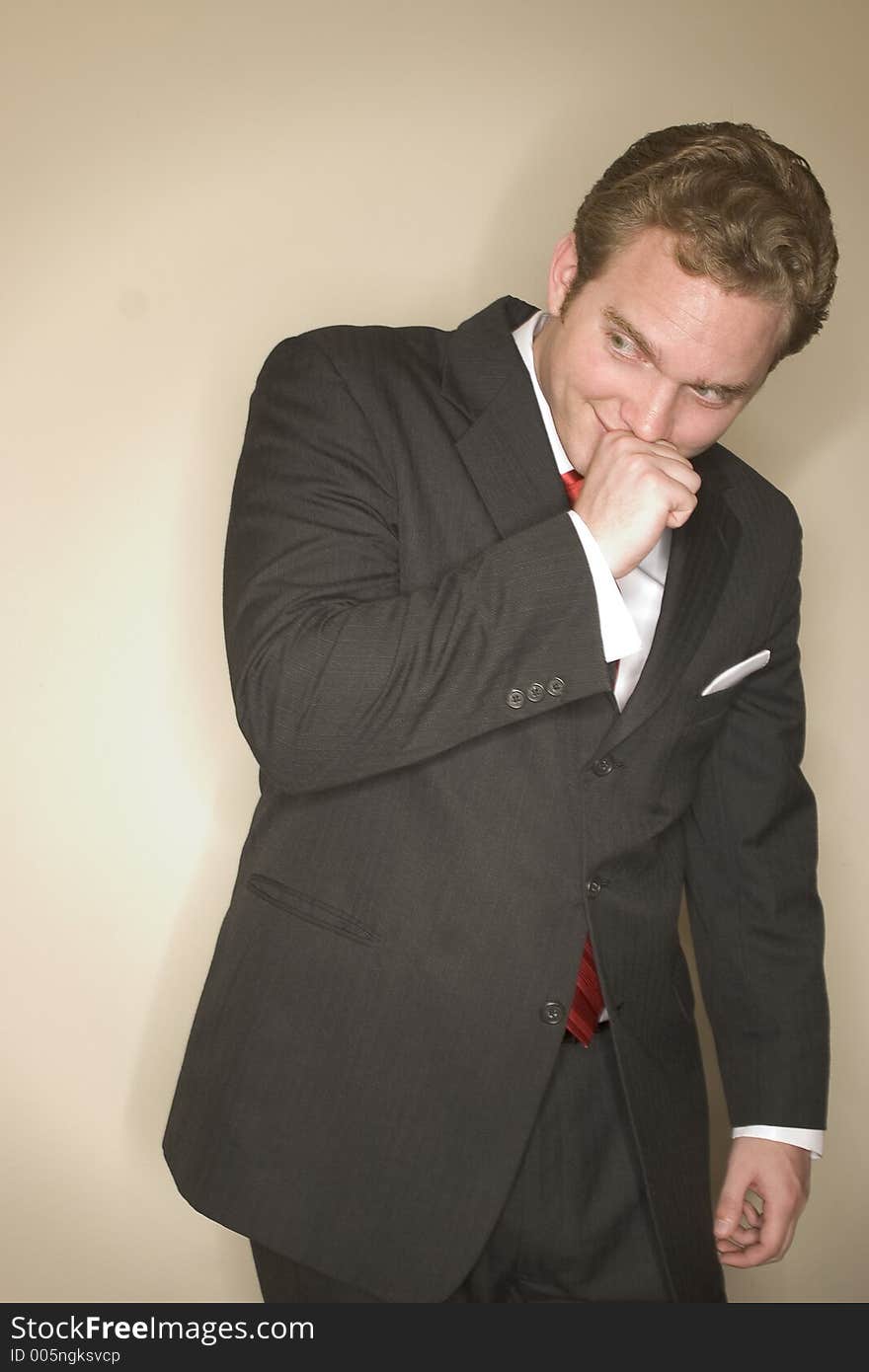 Business man dressed in black suit, red tie, and white shirt has a clever look on his face as he holds his hand to his chin. Business man dressed in black suit, red tie, and white shirt has a clever look on his face as he holds his hand to his chin