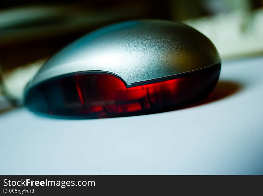 Closeup of an optical mouse on white underground; with trendy shallow depth of focus field;