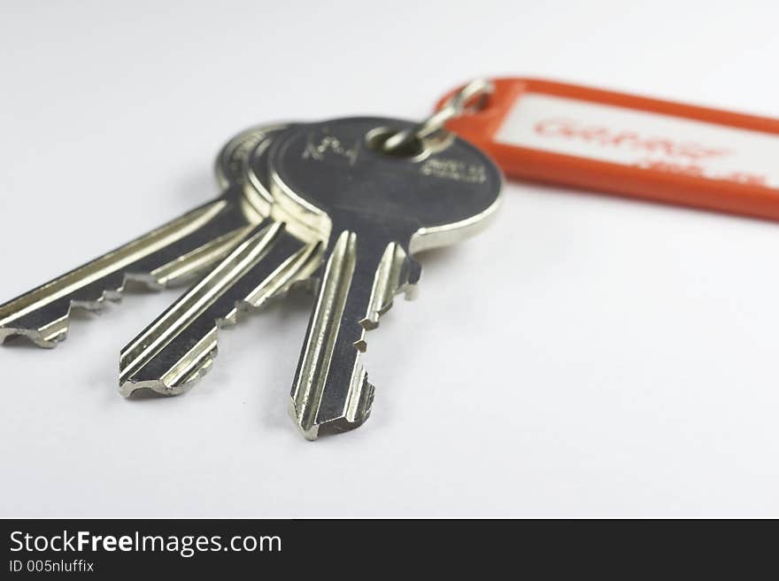 Keys with a red key fob on white background. Keys with a red key fob on white background