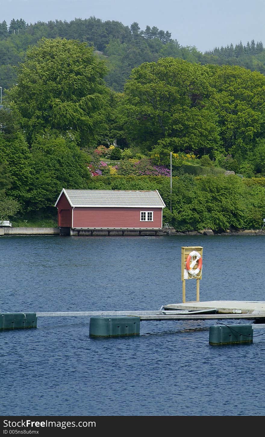 Floating boathouse and lifesaving ring on a floating quay at Farsund on the south coast of Norway