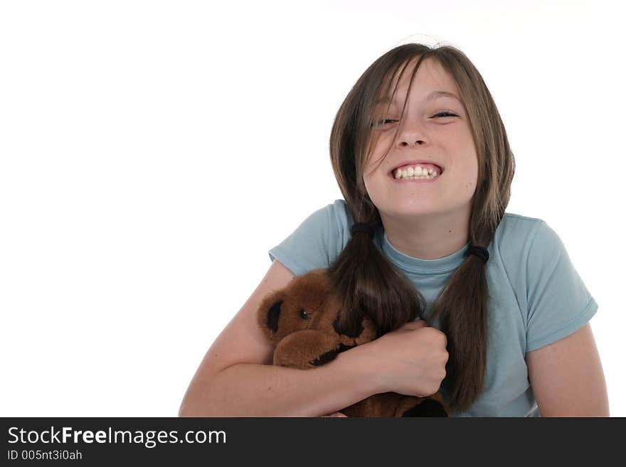 Little girl with big, cheshire cat grin, smiling and sitting on floor holding a teddy bear.  Shot on white. Little girl with big, cheshire cat grin, smiling and sitting on floor holding a teddy bear.  Shot on white.