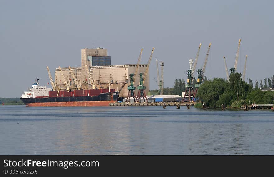 View at elevator and ship moored near harbour riverside. View at elevator and ship moored near harbour riverside