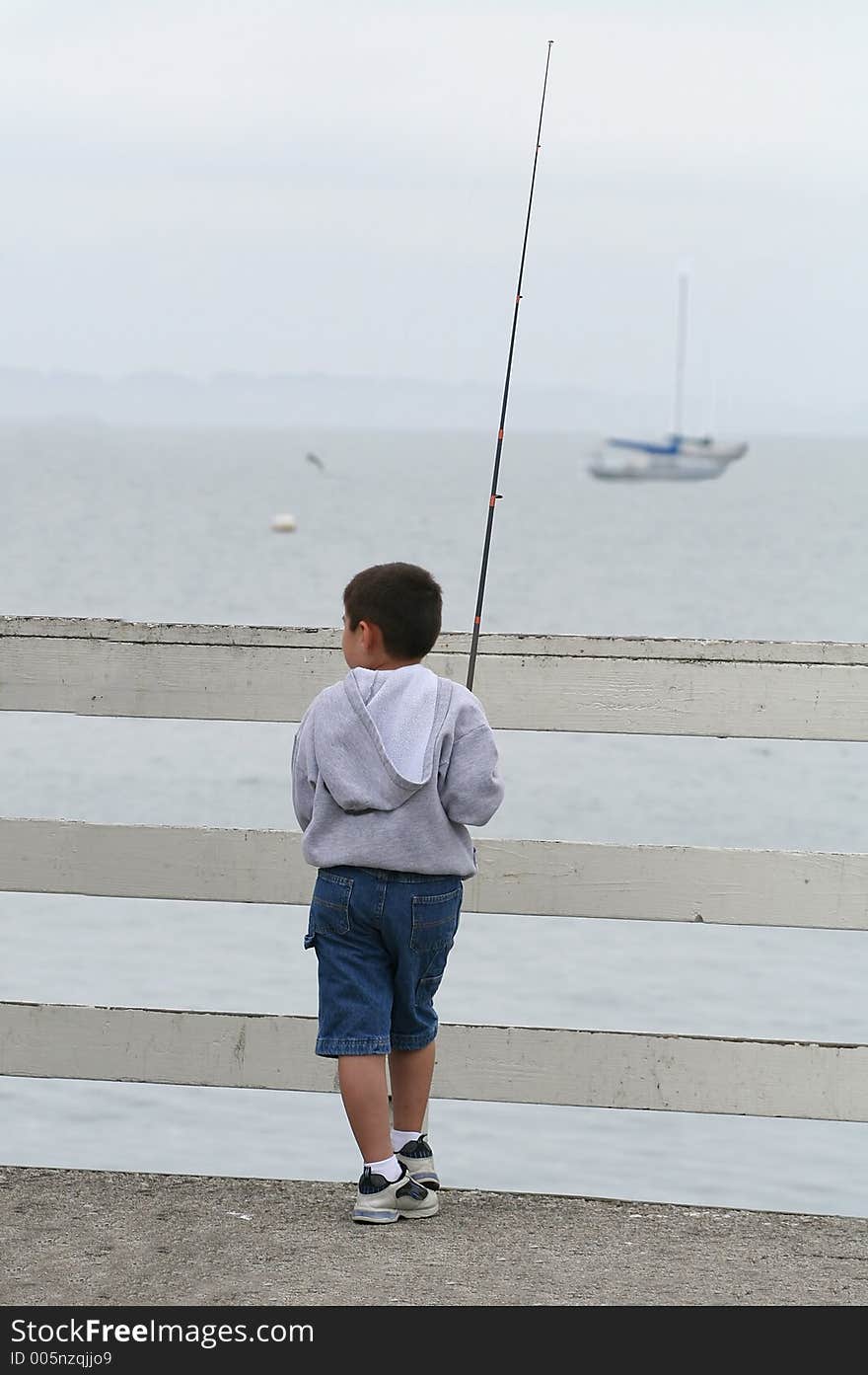 A boy fishing from the pier